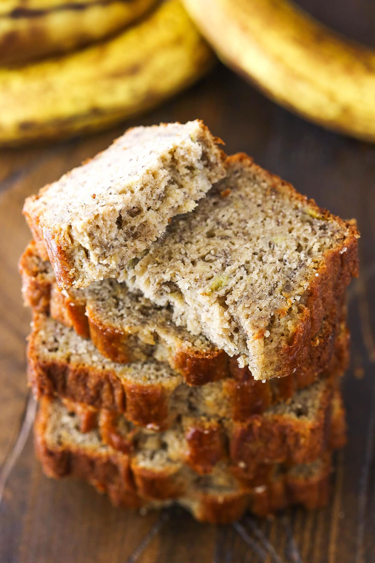 Slices of Banana Bread stacked on top of each other with the top slice broken in half