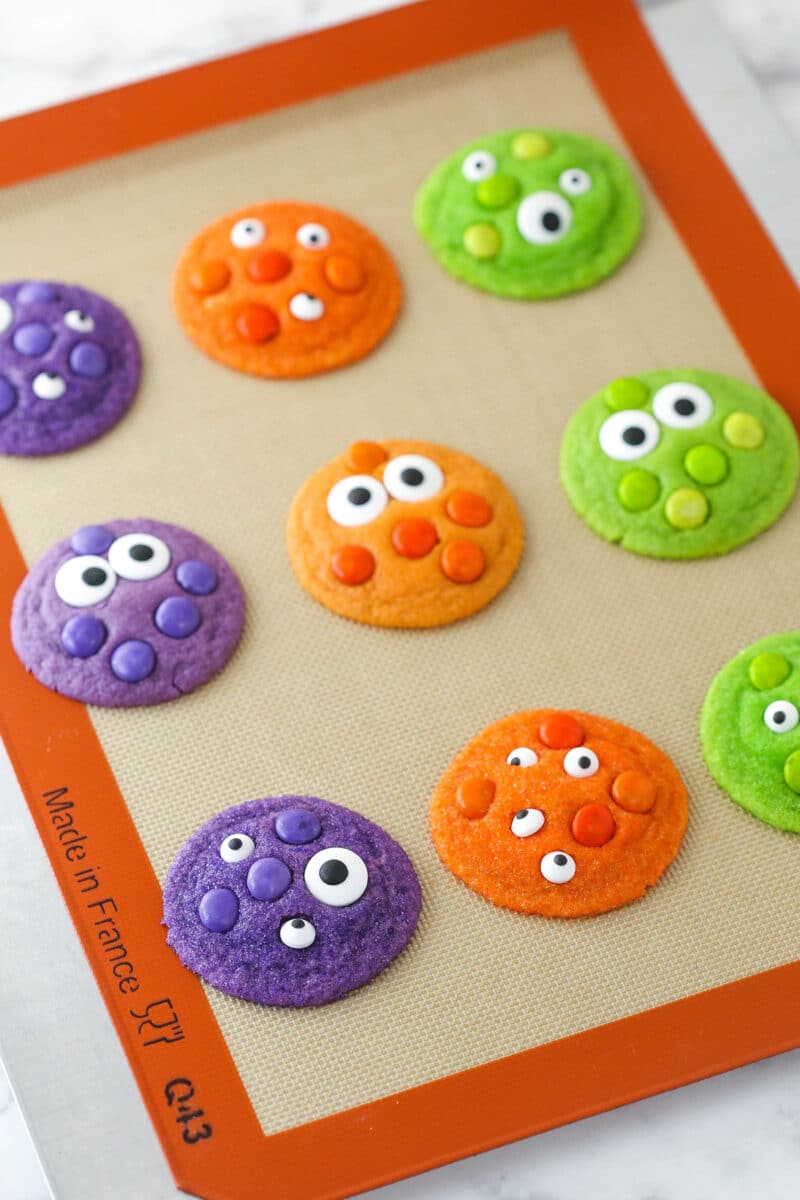 A silicone mat with baked Halloween Monster Cookies.