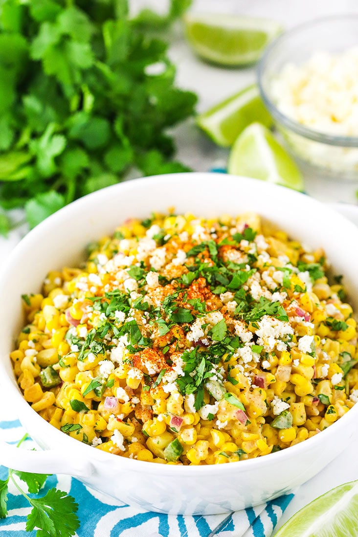 corn salad in a white dish with cilantro in the background
