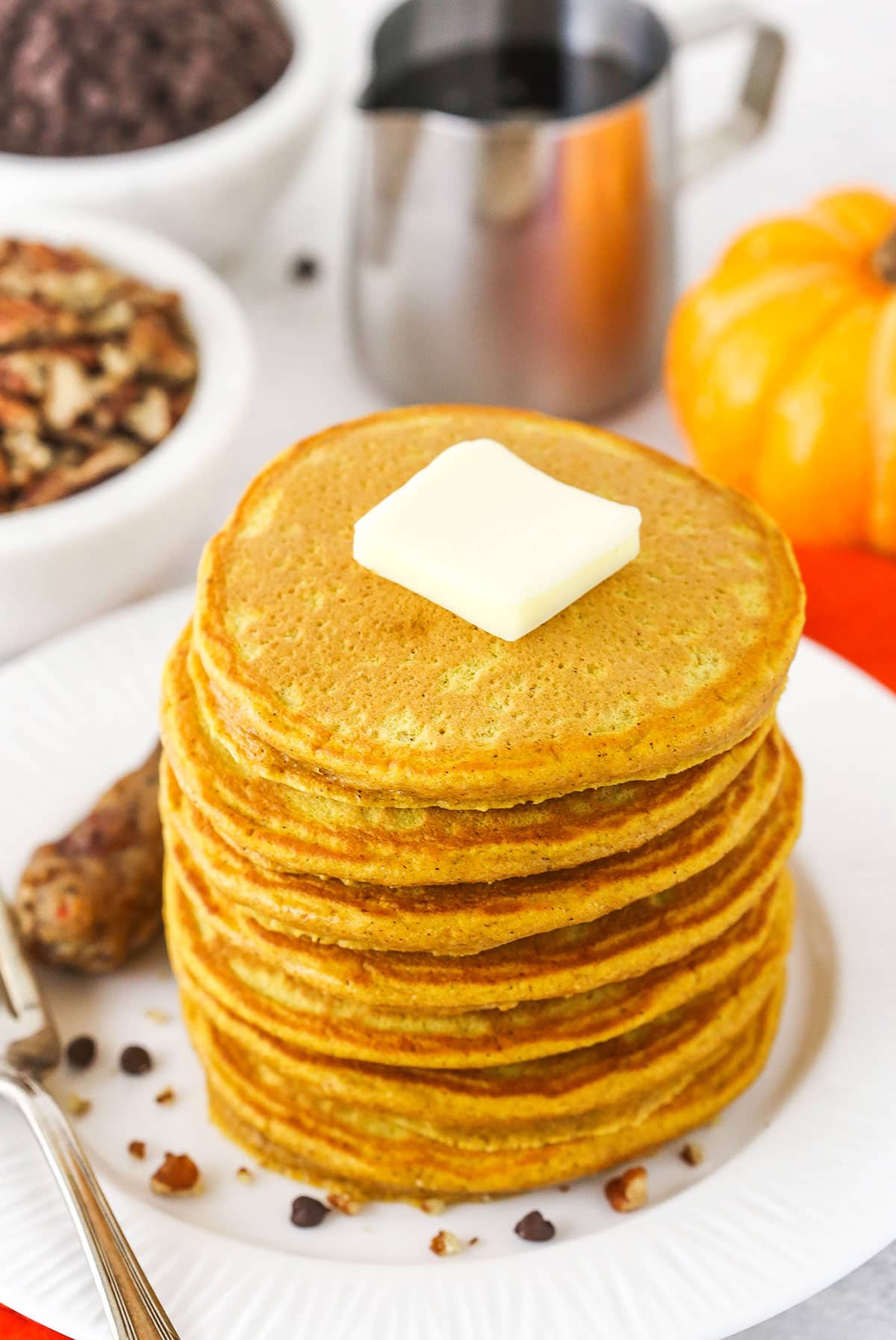 Fluffy pumpkin pancakes topped with a square of butter.